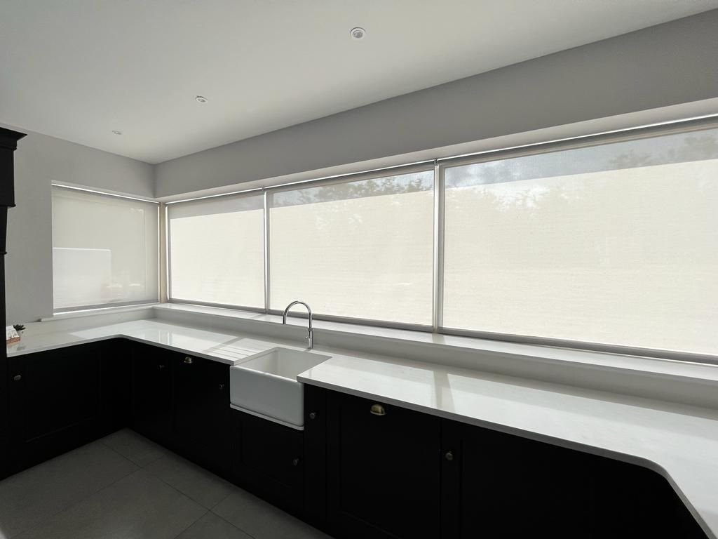 Best blinds for kitchens: white screen roller blinds fitted above a kitchen sink in a Meath home
